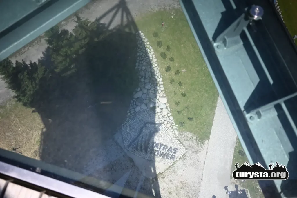 Widok w dół przez przeszkloną podłogę na wysokości 50 metrów na wieży Tatras Tower