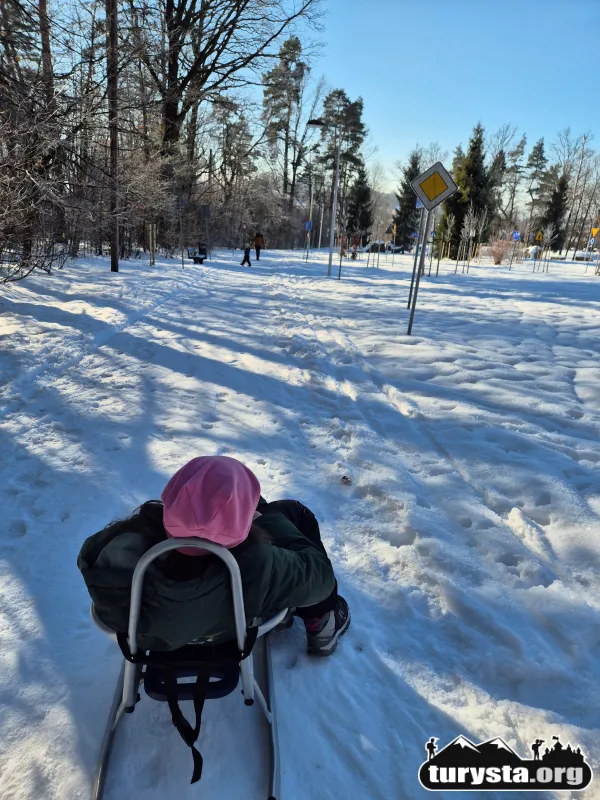 Zimowy widok na Miasteczko Rowerowe w Rabce z ubitym śniegiem, idealnym do ciągnięcia sanek.