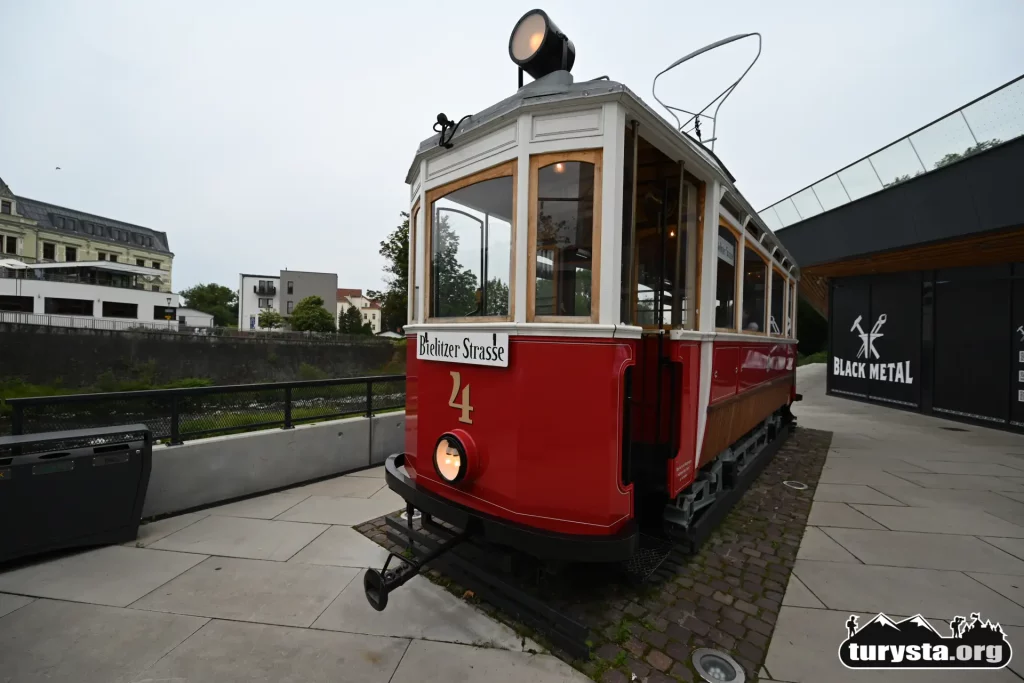 Czerwona replika zabytkowego tramwaju stojąca na dawnym torowisku w Cieszynie.