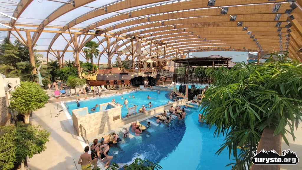 Kryta hala basenowa Tropical Paradise w Aquaparku Tatralandia na Słowacji z żywymi palmami.
