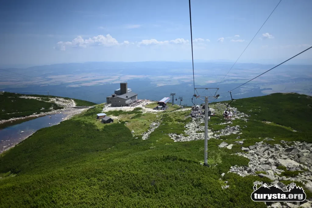 Panorama Łomnickiego Stawu i obserwatorium astronomicznego ze zjeżdżającego wyciągu