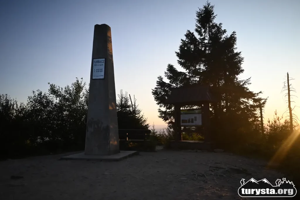 Kamienny obelisk na szczycie Turbacza z widokiem na okolice